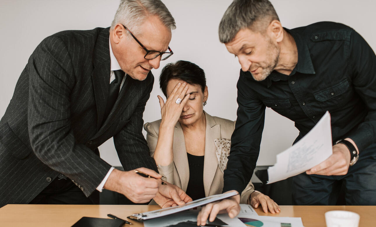 The image depicts a group of people smiling and shaking hands, satisfied with negotiated settlement agreement